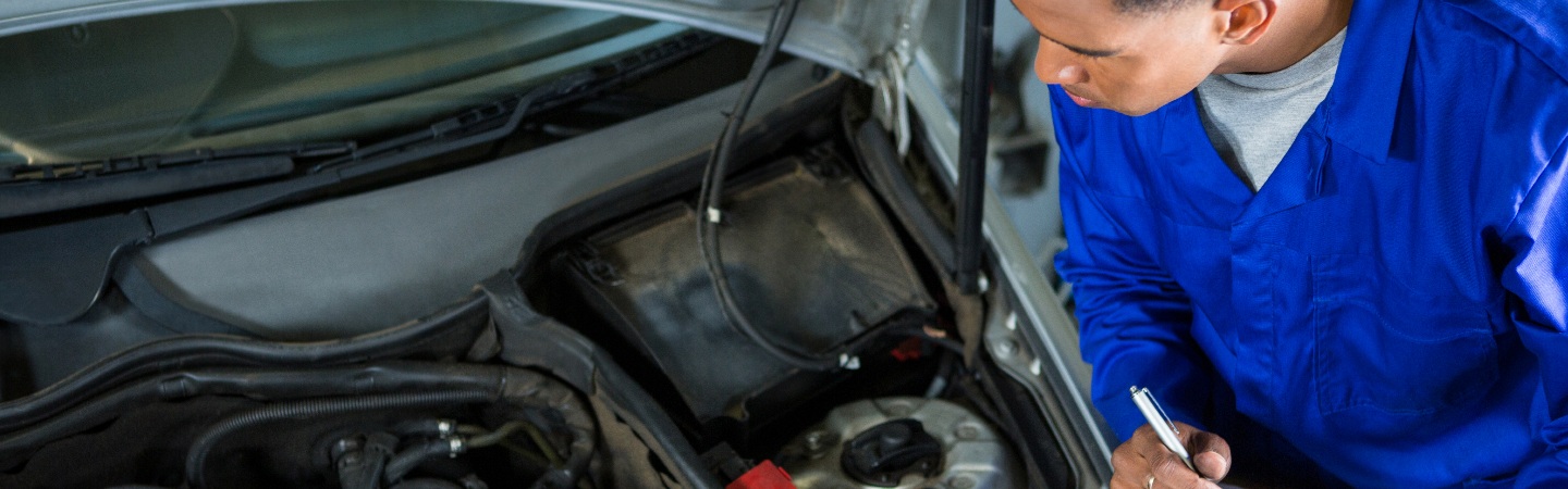hombre revisando el motor de un carro