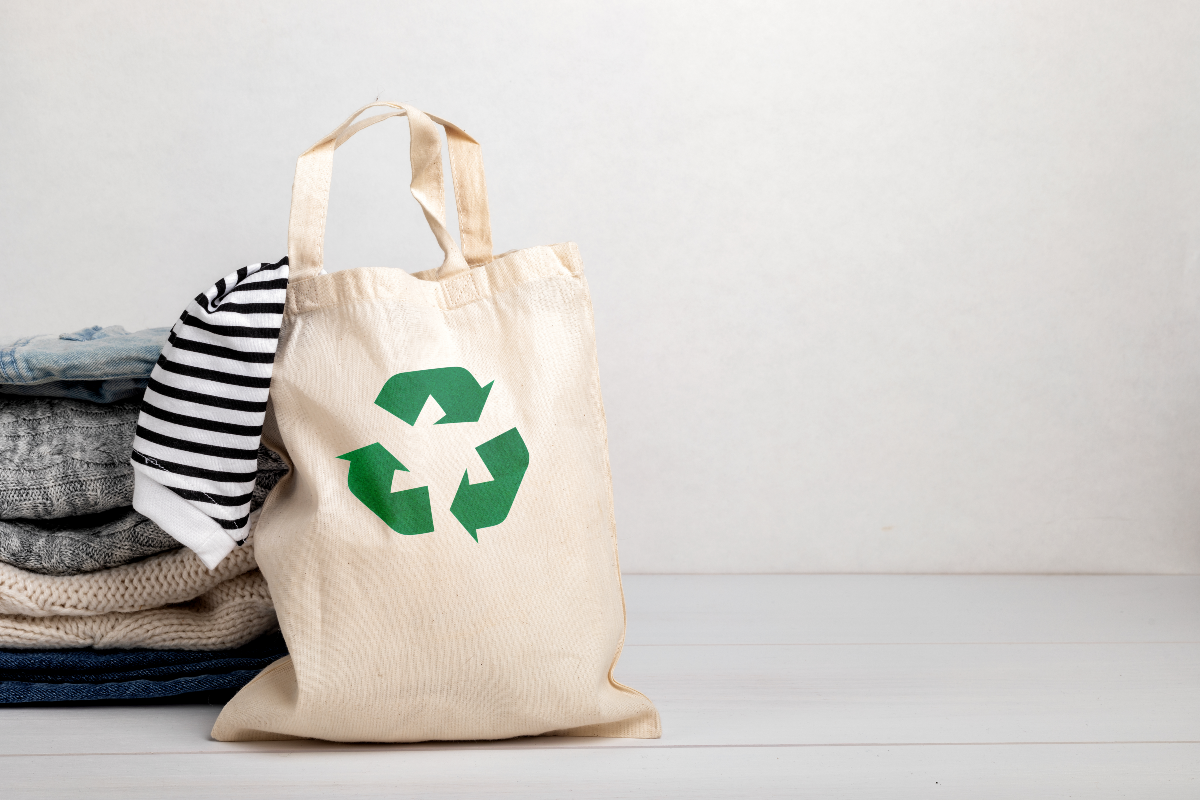 Bolsa de tela con ropa apilada a un costado
